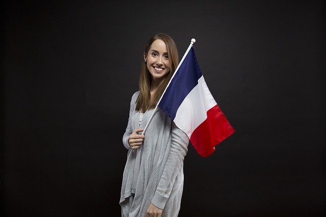 Mulher segurando a bandeira da França e as razões para aprender francês