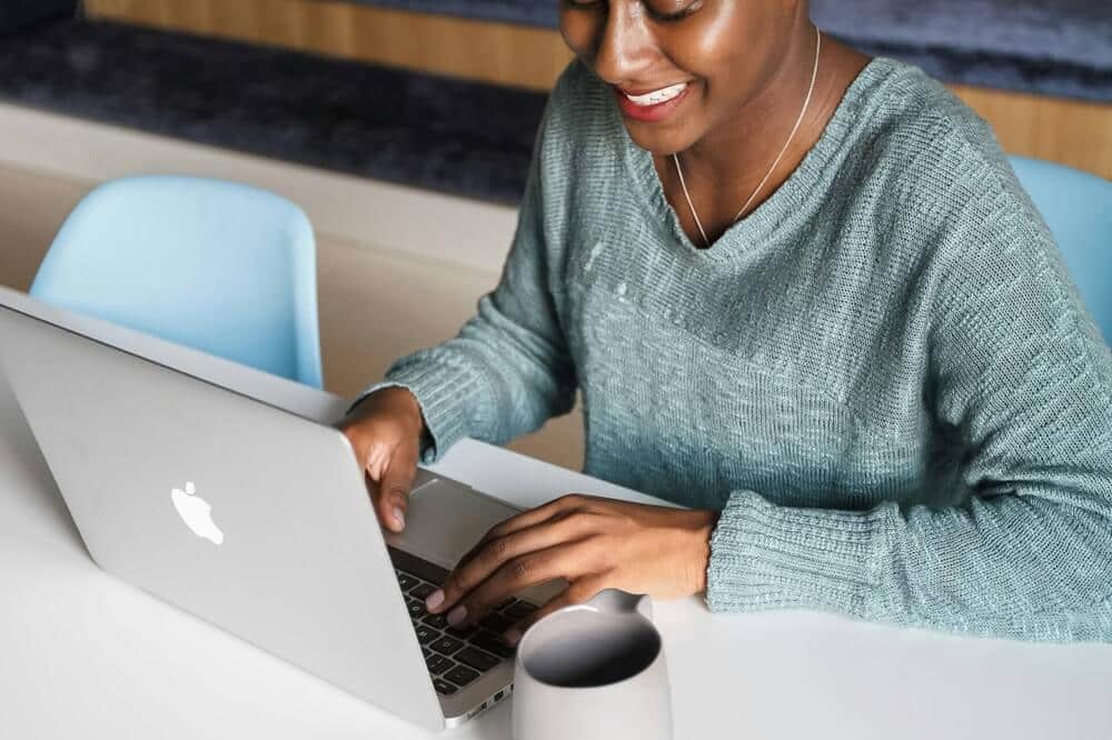 Mulher usando computador para criar um perfil no linkedin para emprego no exterior